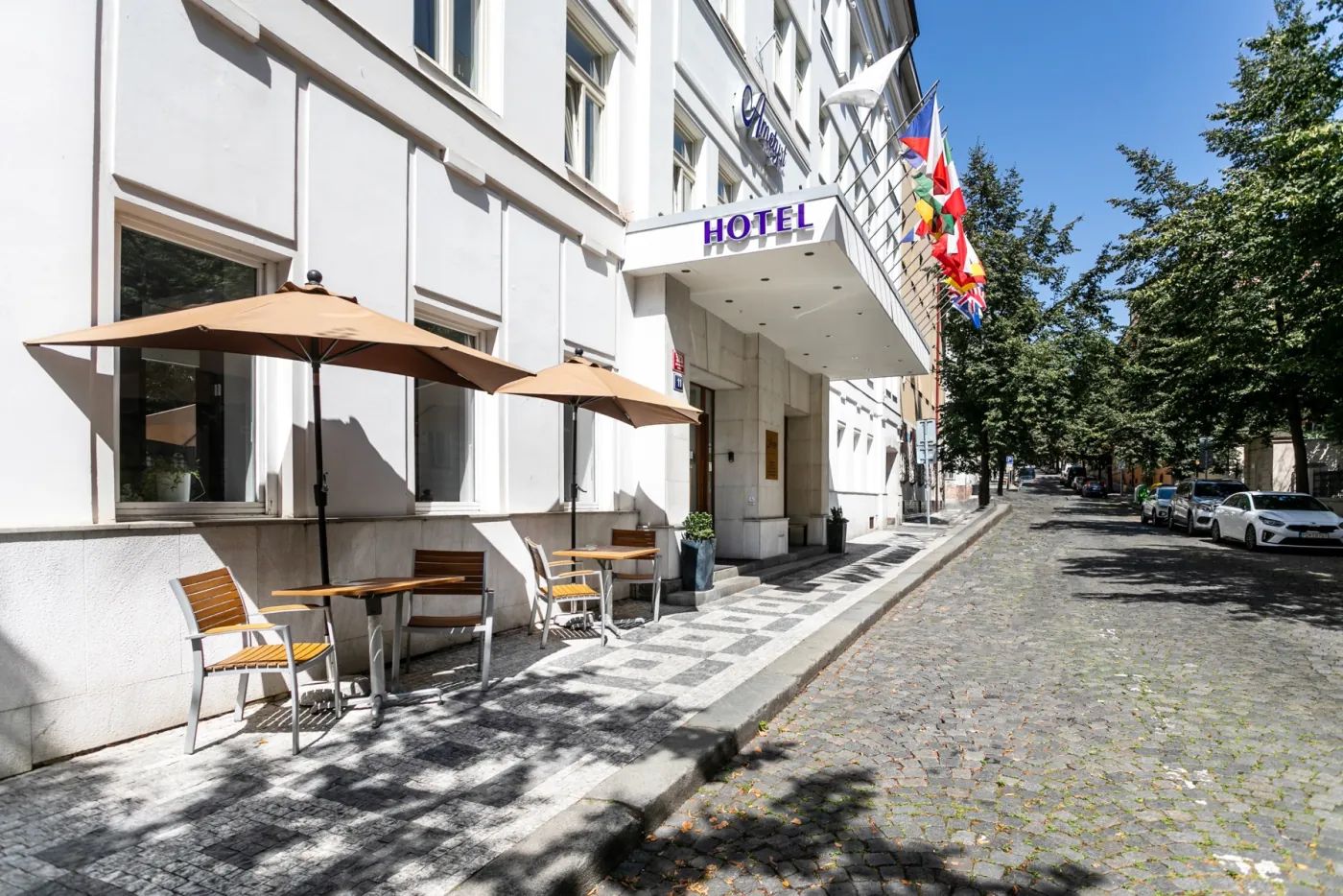 Hotel Ametyst v dlážděné ulici se stromy na Vinohradech